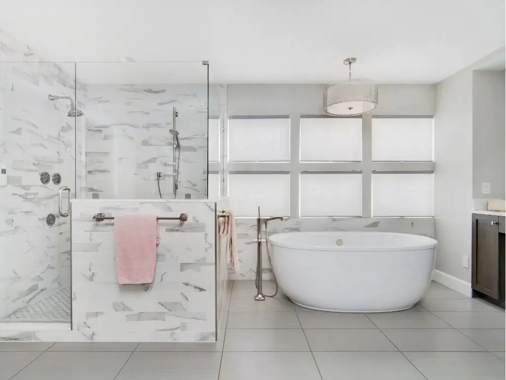 Kitchen and bath remodeling Sarasota FL: primary bathroom with freestanding tub, marble-look tile walk-in shower and large-format porcelain floor