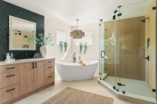 Bathroom remodel with natural wood vanity, dark green tile accent wall, freestanding tub and glass shower